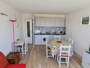 eine Küche und ein Esszimmer mit einem Tisch und Stühlen in der Unterkunft Appartement Vaux-sur-Mer, 2 pièces, 4 personnes - FR-1-550-22 in Vaux-sur-Mer