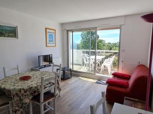 ein Wohnzimmer mit einem roten Sofa und einem Tisch in der Unterkunft Appartement Vaux-sur-Mer, 2 pièces, 4 personnes - FR-1-550-22 in Vaux-sur-Mer