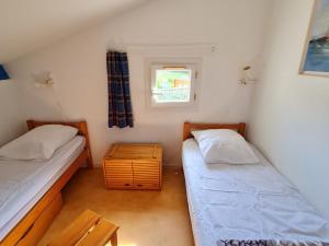 2 Betten in einem kleinen Zimmer mit Fenster in der Unterkunft Appartement Les Mathes, 3 pièces, 4 personnes - FR-1-550-13 in Les Mathes