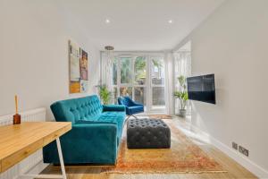 a living room with a blue couch and a table at Homely 1Bed Apartment Vauxhall in London
