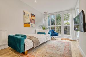 a bedroom with a bed and a chair and a window at Homely 1Bed Apartment Vauxhall in London