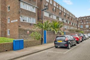 a car parked in a parking lot next to a brick building at Homely 1Bed Apartment Vauxhall in London