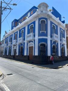 un edificio azul y blanco al lado de una calle en La Casona de Palacio Viejo, en Arequipa
