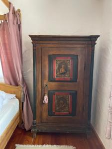 a wooden cabinet next to a bed in a room at Jurahaus Hirschberg EG Wohnung in Beilngries