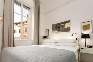 a white bedroom with a white bed and a window at Apartment Pula Mon Amour in Pula