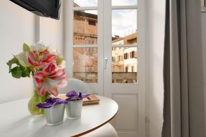 a vase of flowers on a table with a window at Apartment Pula Mon Amour in Pula