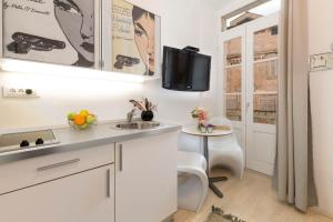 a kitchen with white cabinets and a sink and a table at Apartment Pula Mon Amour in Pula