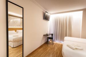 a mirror in a hotel room with a bed and a bedroom at Hotel Dauro Premier in Granada