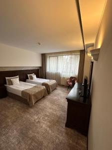 ein Hotelzimmer mit 2 Betten und einem TV in der Unterkunft Hotel Alpin Aparthotel Apartament 301 in Poiana Brașov