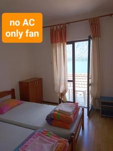 1 dormitorio con 1 cama y puerta con balcón en Seaside apartments and rooms, en Kotor
