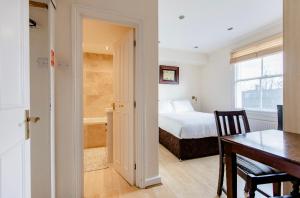 ロンドンにあるベレスフォード ロード ロンドン ルームズのベッドルーム1室(ベッド1台、テーブル付)、ダイニングルームが備わります。
