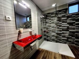 a bathroom with a red sink and a shower at O Abel Hotel rural in Bragança