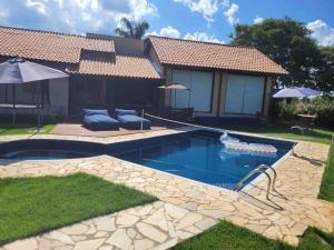 una piscina frente a una casa en Linda Casa de Campo Nova em condomínio, en Porangaba