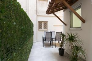 un comedor con sillas y una pared verde en Callirhoē Luxury 2BD Acropolis Apartment, en Atenas