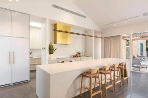 une cuisine avec un grand comptoir blanc et des chaises dans l'établissement SORRENTO ViLLA HOLLYWOOD, à Sorrento