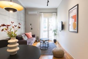 una sala de estar con un sofá y una mesa en Callirhoē Luxury 2BD Acropolis Apartment, en Atenas