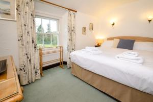 a bedroom with two beds and a window at Nans, Elterwater in Chapel Stile