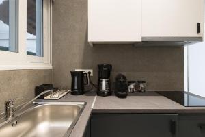 Una cocina con un fregadero y una cafetera en la encimera. en Callirhoē Luxury 2BD Acropolis Apartment, en Atenas 24 fotos más
