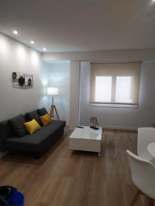 sala de estar con sofá negro y mesa en Apartamentos turísticos Demar, en O Grove