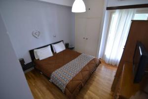 een slaapkamer met een bed en een televisie. bij Το σπίτι μας in Athene