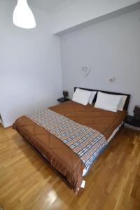 een groot bed in een slaapkamer met een houten vloer bij Το σπίτι μας in Athene
