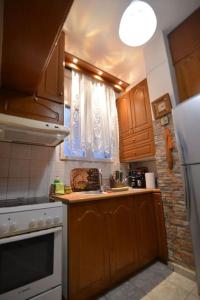 een keuken met houten kasten en een witte koelkast bij Το σπίτι μας in Athene