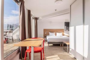 a hotel room with a bed and a table at Residhotel Le Central'Gare in Grenoble