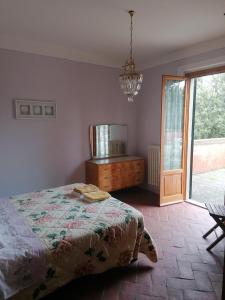 PolveretoにあるCasa Rossaのベッドルーム1室(ベッド1台、窓、シャンデリア付)