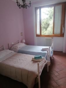 PolveretoにあるCasa Rossaのベッドルーム1室(ベッド2台、テーブル、窓付)