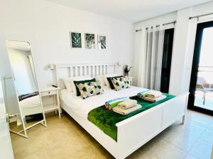 a bedroom with a white bed with a desk and a mirror at Casa Vista in Caleta De Fuste +32 photos