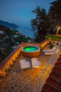 una piscina con due sedie a sdraio accanto a una scala di Villa Nina Amalfi ad Amalfi