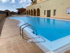 a large swimming pool with blue water in a building at Casa Vista in Caleta De Fuste