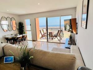 a living room with a couch and a table with chairs at Casa Vista in Caleta De Fuste