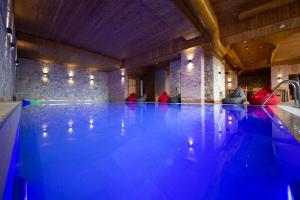 kryty basen z niebieskim oświetleniem w pokoju w obiekcie Aerial Hotel & Spa we Wlorze