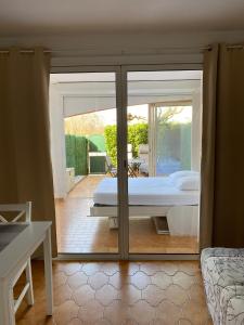 um quarto com uma cama e uma porta de vidro deslizante em Les locations Cinaureva ­« L'Argentière » em La Londe-les-Maures