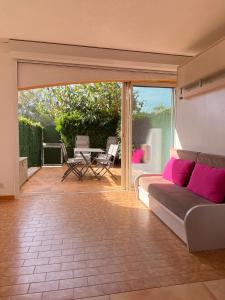 un salon avec un canapé et une terrasse dans l'établissement Les locations Cinaureva ­« L'Argentière », à La Londe-les-Maures