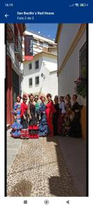un grupo de mujeres están de pie en una calle en San Basilio´s Red House, en Córdoba