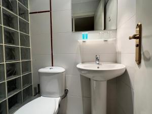Baño blanco con aseo y lavamanos en THC Gran Via Hostel en Madrid