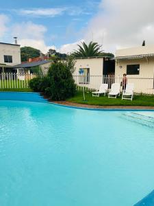 a swimming pool with blue water in front of a house at Munisa Guest House in Johannesburg