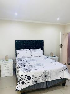 a bedroom with a bed with a black and white comforter at Munisa Guest House in Johannesburg