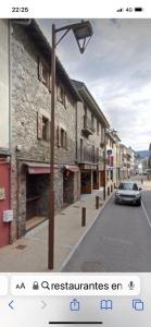un coche conduciendo por una calle al lado de un edificio en Apto cerca de Puigcerda con chimenea, en Bourg-Madame