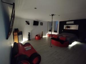 un salon avec un canapé rouge et une chambre avec deux chats dans l'établissement why not, à Lédignan