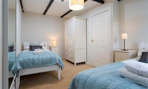 a bedroom with two beds and a mirror at Christmas Cottage in Chapel Stile +3 photos