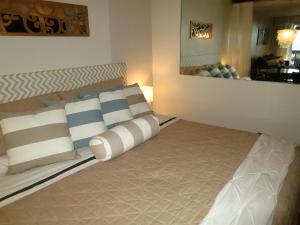 ein Schlafzimmer mit einem Bett mit Kissen darauf in der Unterkunft Luxury Beachfront King Suite on Sapphire Beach II in East End