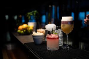un tavolo con due cocktail e un bicchiere di vino di Hôtel Restaurant Le Monêtier a Le Monêtier-les-Bains