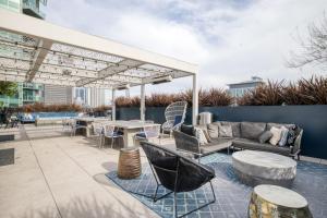 a patio with couches and tables and a pergola at Downtown 1BR w Pool Gym nr Staples Center LAX-625 in Los Angeles