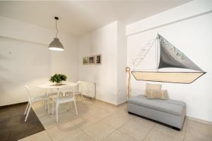 a living room with a table and a sailboat on the wall at City Beach Apartment in Chania
