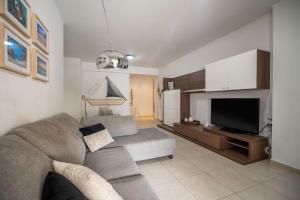 a living room with a couch and a flat screen tv at City Beach Apartment in Chania Town