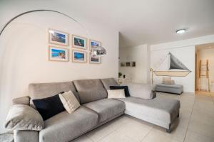 a living room with a gray couch and some pictures at City Beach Apartment in Chania Town