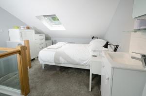 a white bedroom with a bed and a sink at Cherry Tree Cottage in Chapel Stile
